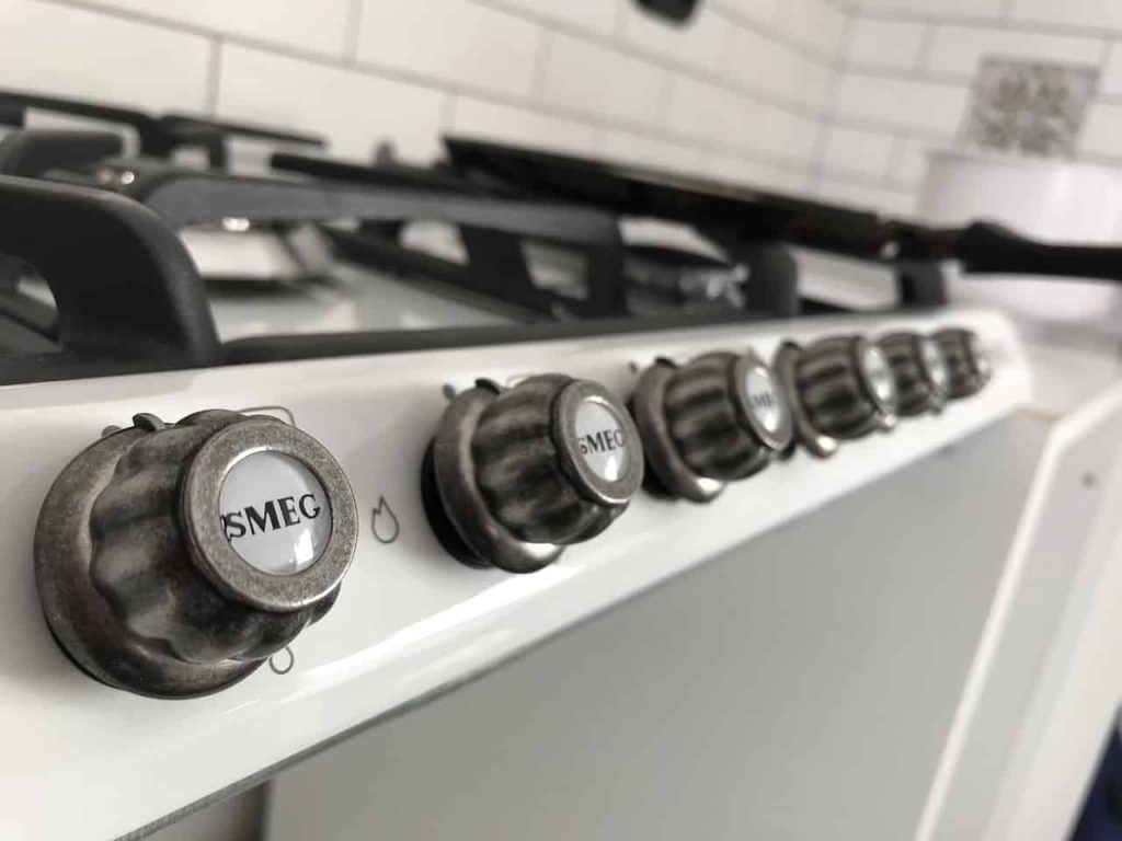 closeup of oven hobs with the brand smeg written on them